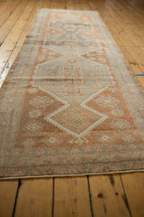 Distressed vintage Oushak rug detail, showing copper and silver medallion, floral motifs, and vine border.