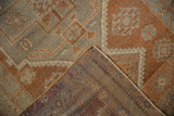 Vintage distressed Oushak rug corner showing muted copper, gray geometric patterns and original selvage.