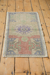 Distressed Oushak rug showing geometric contours in brick red, seafoam, and visible knot wear.