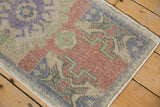 Geometric pattern detail on abrashed vintage Oushak rug with faded purple, red, and green.