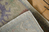 Distressed vintage Oushak rug corner with textured pile and intact side selvage.