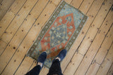 Distressed vintage Oushak rug mat displaying faded rust and dusty royal blue patterns.