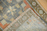 Distressed Oushak rug showing short pile texture in muted tones and neatly woven reverse.