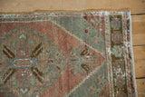 Distressed Oushak rug corner detail, revealing pile wear, visible foundation, slate, and aubergine.