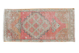Distressed vintage Oushak rug with pink field, central medallion, and muted floral details, 1'6
