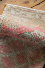 Distressed Oushak rug pile texture with worn knot heads in pink and beige.