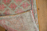 Distressed Oushak rug's hand knotted foundation, pink and green pile, with yellow selvage.