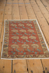 Distressed Oushak rug with chestnut and ivory floral pattern and visible even wear texture.