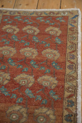 Vintage distressed Oushak rug showing chestnut pile, whiskey florals, teal leaves, and worn border.
