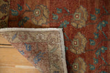 Distressed Oushak rug corner showing hand-knotted foundation, worn chestnut floral pile.