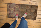 Vintage distressed Oushak mat runner, showcasing even wear, geometric pattern, and warm earth tones.