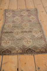 Distressed hand-knotted Oushak rug shows even pile wear and geometric patterns in brown, beige.