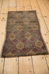 Distressed Oushak rug, showing geometric floral panels in coffee brown, aubergine, and beige.