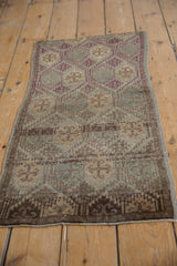 Distressed vintage Oushak runner showcasing geometric floral motifs and even wear to knot heads.