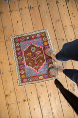 Distressed hand-knotted vintage Oushak mat corner showing faded copper field, blue motif, and colorful border.