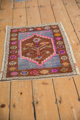 Vintage Oushak mat corner showing distressed copper border and faded blue field.