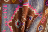 Distressed Oushak rug pile with stepped geometric copper, slate blue, and vivid pink patterns.