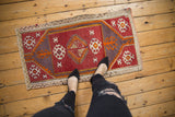 Distressed Turkish Jijim rug, geometric guls, wine red field and dusty violet spandrels.