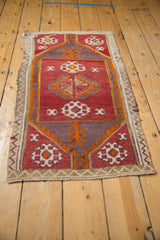 Detailed central geometric floral gul on distressed vintage Jijim rug, red and orange.