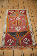 Distressed vintage Turkish Jijim rug detail with geometric guls in wine red and tangerine.