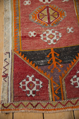 Distressed Jijim rug lower edge, showing fringe, zigzag border, and orange plant motif.