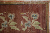 Vintage Turkish Oushak rug detail: distressed copper floral motif, green accents, and worn gold banded border.