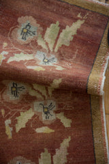 Worn copper and beige floral pattern on the distressed pile of a vintage Oushak rug.