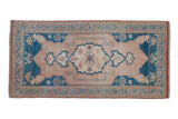Vintage distressed Oushak rug with pearl-adorned rose field, sapphire blue medallion, floral borders.