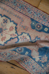 Softly worn texture of a distressed Oushak rug in sapphire blue and dusty rose.