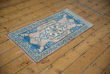 Distressed Oushak rug corner with pale sapphire blue and dusty rose floral borders.