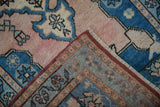Corner view reveals distressed pale dusty rose pile and intricate hand-knotted Oushak rug reverse.