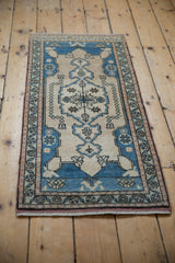 Close-up of distressed vintage Oushak rug showing time-softened pile and blue, ivory, sea foam floral border.
