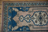 Pinwheel floral border and pearl-adorned main field with even wear on a vintage Oushak rug.