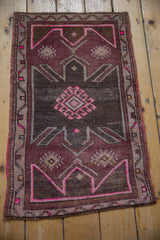Fuchsia hook and latch diamond medallion on a distressed Oushak rug.