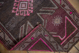Vibrant fuchsia side cord on distressed vintage Oushak rug's folded edge.
