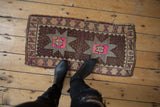 Distressed Oushak rug mat with softened pile, double starburst, and bright pink accents.
