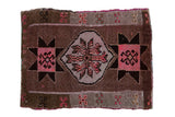 Distressed vintage Oushak square mat, central floral medallion, geometric starbursts, pink and brown.