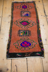 Distressed vintage Oushak runner, showcasing playful floral medallions and border on a sandalwood field. 1'3