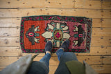 Distressed Oushak rug runner with bright fuschia and madder root red abrash pattern underfoot.