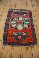 Distressed Oushak rug's oversized floral design with madder root, fuschia, and turquoise tones.