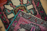 Vintage distressed Oushak rug corner, geometric patterns, fuschia, beige, turquoise selvage.