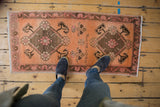 Distressed Oushak runner with pale terracotta, raspberry double medallions, and weaver name.