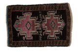 Vintage distressed Oushak mat with two geometric medallions in mauve on a charcoal black field.