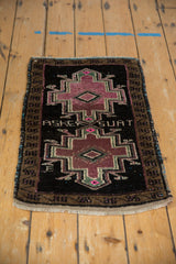 Angled view of the distressed Oushak mat's double medallion and weaver inscription.