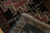 Close-up of the weaver's name inscribed in the charcoal pile of a vintage Oushak rug.