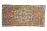 Distressed Turkish Oushak rug mat with faded rust scalloped medallion and pale blue-gray spandrels.