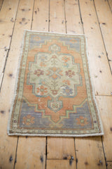 Distressed vintage Oushak rug mat, faded rust and pale royal blue scalloped medallion.