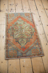 Decorative faded rust, pale blue geometric patterns on a distressed Oushak rug.