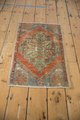 Distressed Oushak rug medallion, geometric blossoms in faded rust, blue, green.