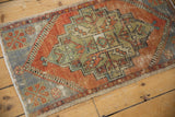 Corner of distressed Oushak rug with faded rust, pale blue geometric spandrel, and visible wear.